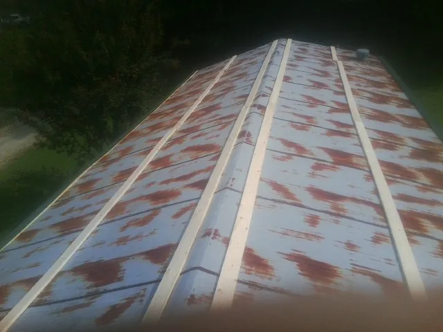 Rusted metal roof panels with new wood purlins before replacement — Storm Damage Roof Repair in Guilderland Center by Roofing Brothers