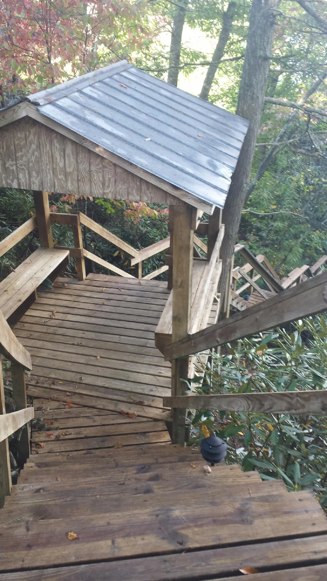 Metal roofed shelter over wooden steps on a wooded walkway — Skylight Repair & Installation work by our crew in Guilderland Center
