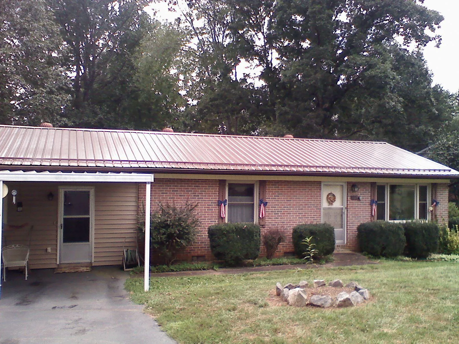 Bronze metal roof and carport on a brick ranch home — Roof Repair work by our crew in Guilderland Center
